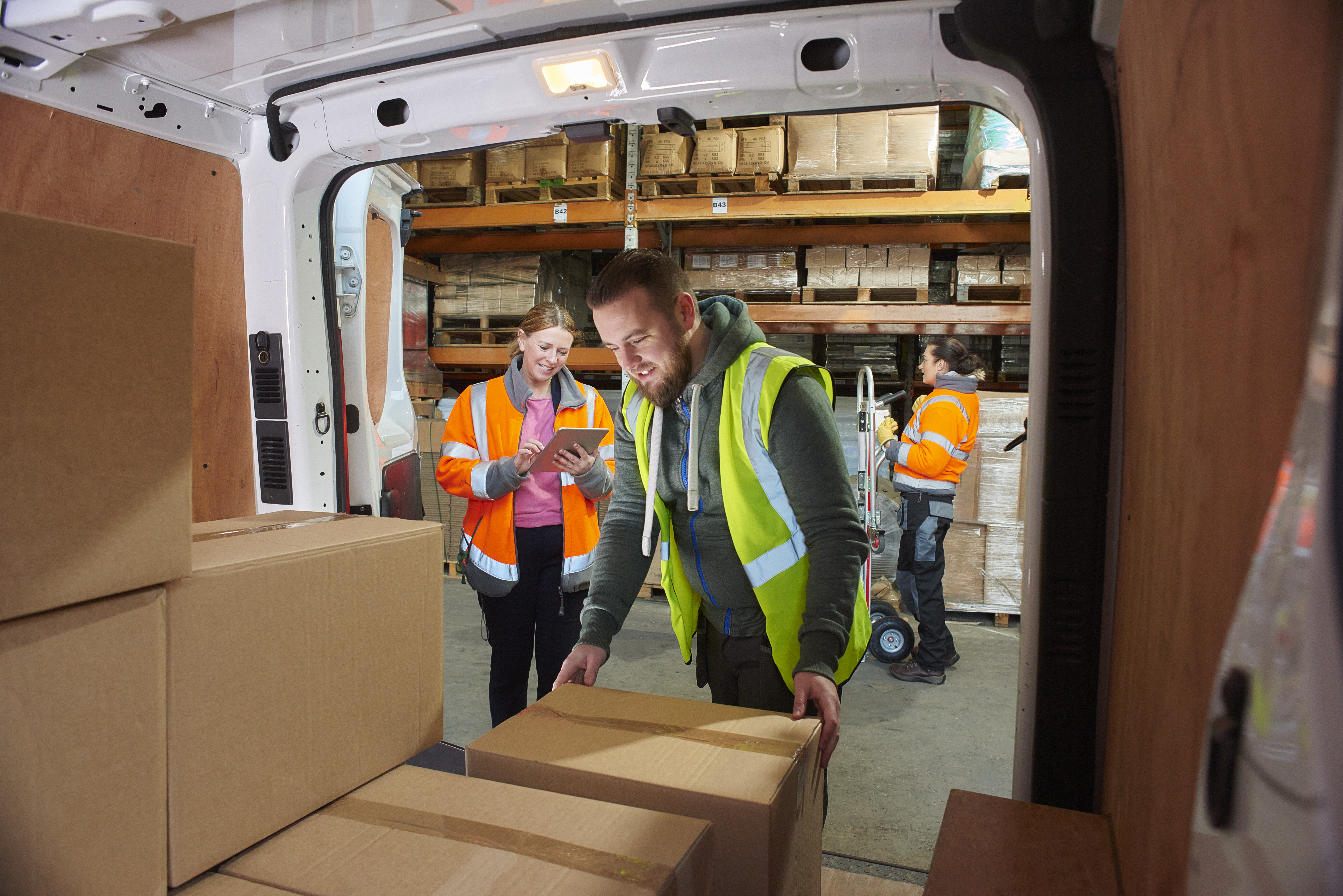 2 people loading boxes into a van